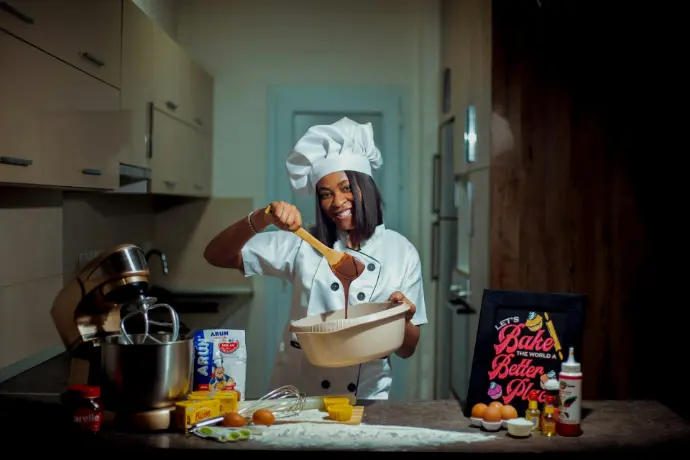 a woman in a chef's hat holding a wooden spoon